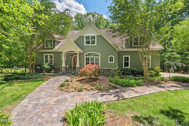 craftsman-style house featuring a front lawn and roof with shingles