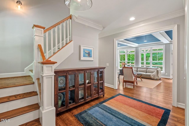stairs with ornamental molding, wood finished floors, baseboards, and recessed lighting