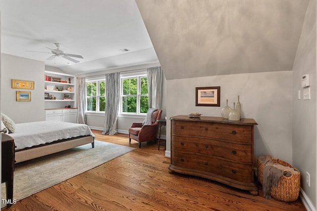 bedroom with vaulted ceiling, wood finished floors, ceiling fan, and baseboards