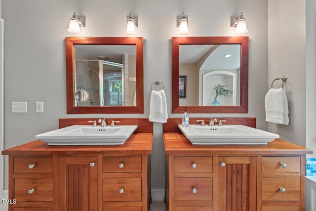 bathroom with a shower stall and two vanities