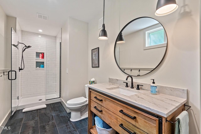 bathroom featuring a stall shower, toilet, vanity, and baseboards