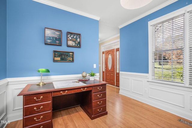 office area featuring ornamental molding, light wood-type flooring, wainscoting, and visible vents