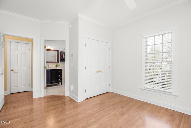 unfurnished bedroom featuring baseboards, light wood-type flooring, and crown molding