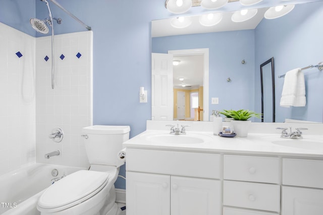 full bath featuring double vanity, tub / shower combination, a sink, and toilet