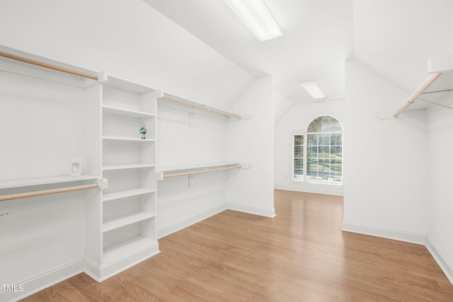 spacious closet with lofted ceiling and wood finished floors