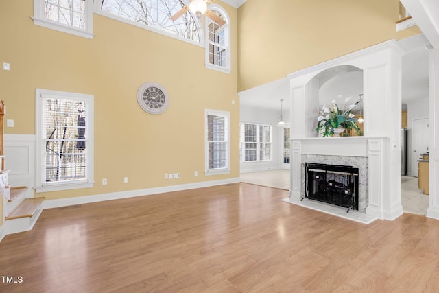 unfurnished living room with a wealth of natural light, a fireplace, and light wood finished floors