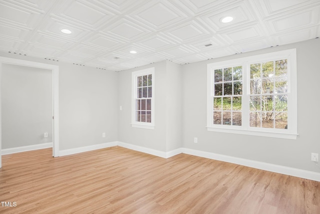 empty room featuring an ornate ceiling, recessed lighting, light wood finished floors, and baseboards