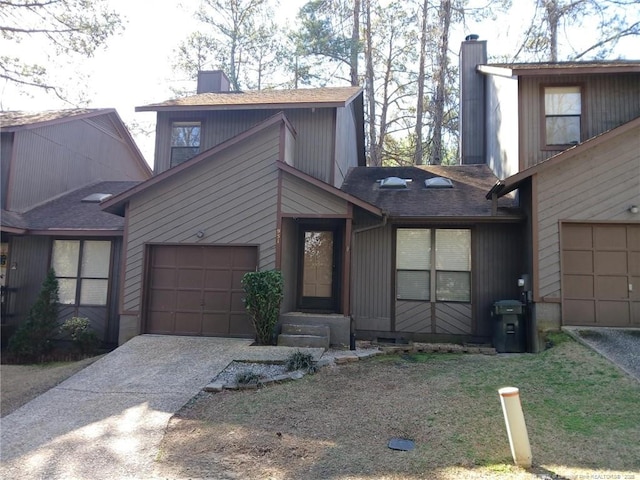 view of front of house with a garage, driveway, and a chimney