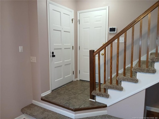 tiled entrance foyer with stairway and baseboards