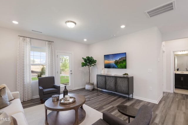 living area with dark wood-style floors and visible vents