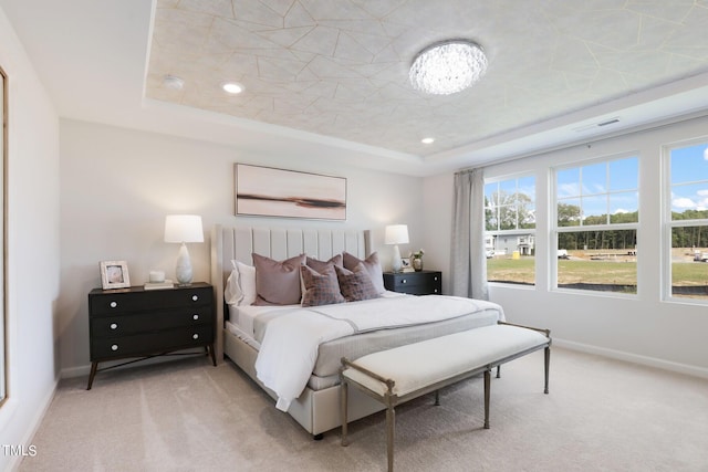 bedroom with carpet, a tray ceiling, baseboards, and recessed lighting