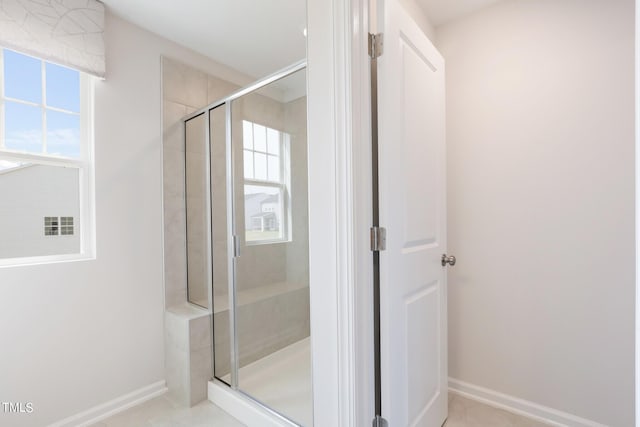 full bathroom featuring a stall shower and baseboards