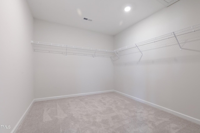 walk in closet featuring visible vents and light colored carpet