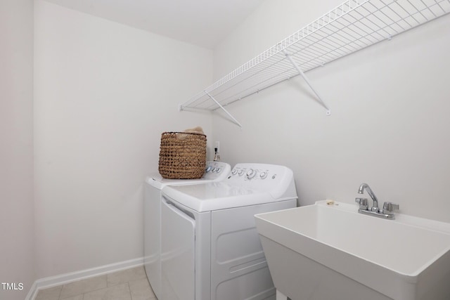 washroom featuring laundry area, baseboards, independent washer and dryer, a sink, and light tile patterned flooring