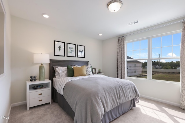 bedroom with light colored carpet, visible vents, and baseboards