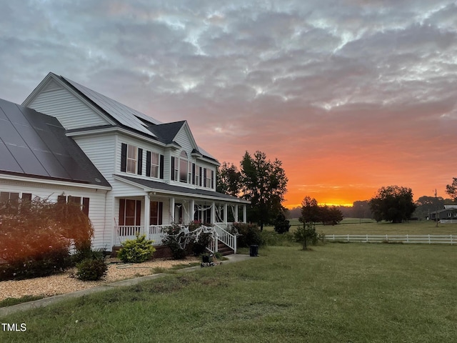 exterior space featuring covered porch and a yard