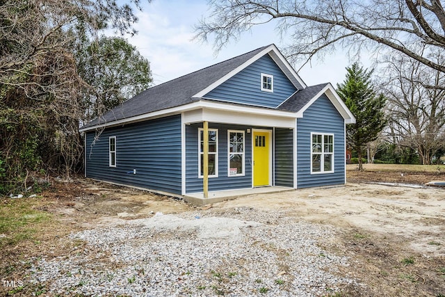 view of front facade featuring covered porch and a shingled roof