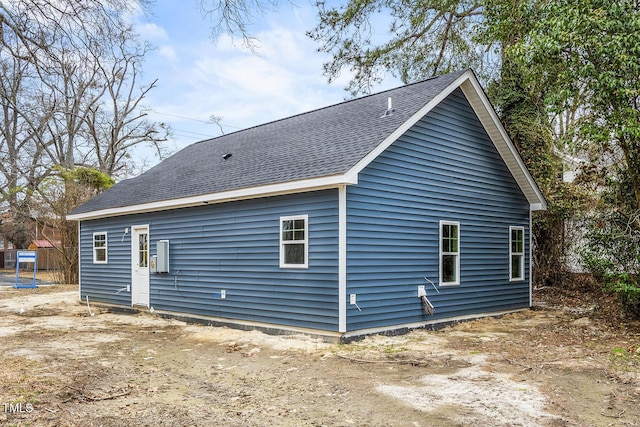 rear view of house with a shingled roof