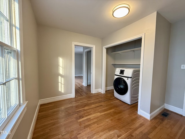 laundry room featuring baseboards, washer / clothes dryer, wood finished floors, and laundry area