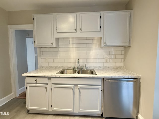 kitchen with a sink, decorative backsplash, white cabinets, dishwasher, and light wood-type flooring