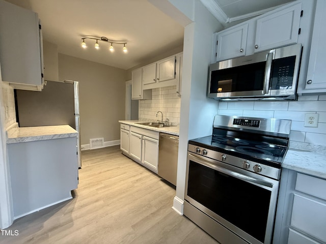 kitchen with visible vents, light wood-style flooring, a sink, stainless steel appliances, and light countertops