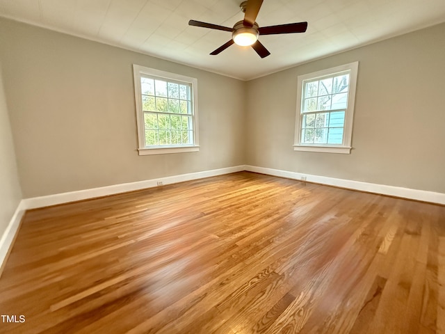 unfurnished room featuring a ceiling fan, wood finished floors, and baseboards