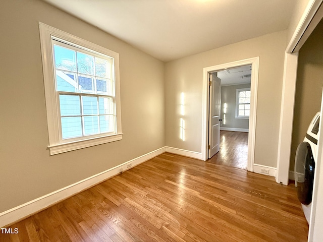 spare room with baseboards and wood finished floors