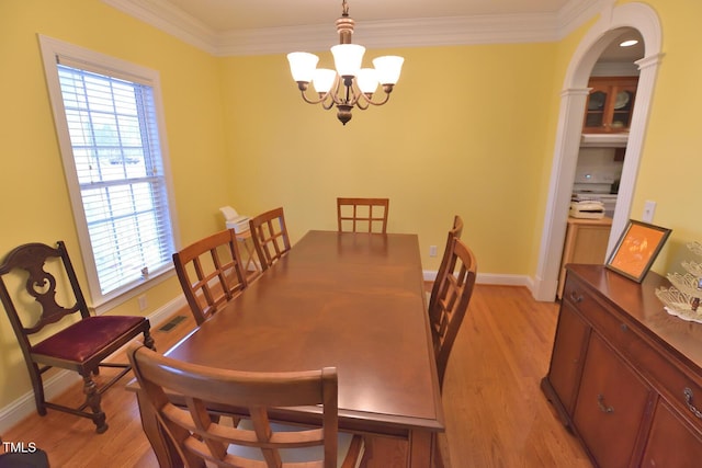 dining area featuring light wood-style flooring, visible vents, ornamental molding, and a notable chandelier