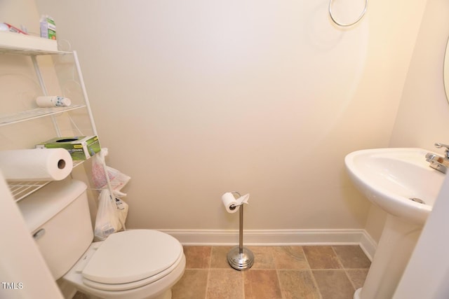 bathroom featuring toilet and baseboards