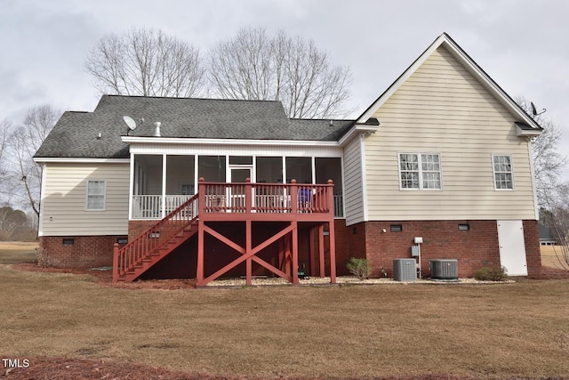 rear view of house featuring a shingled roof, a lawn, a sunroom, stairs, and central air condition unit