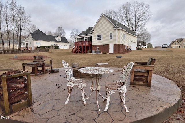 view of patio featuring a garage, a sunroom, outdoor dining area, and stairs