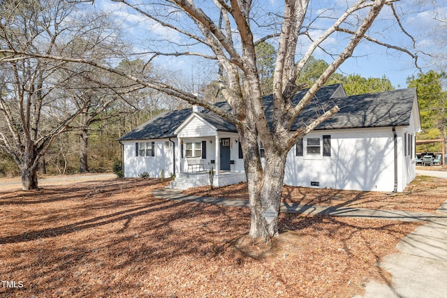 view of front facade with crawl space, covered porch, and roof with shingles