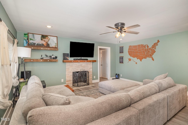 living area with baseboards, a ceiling fan, wood finished floors, a fireplace, and recessed lighting