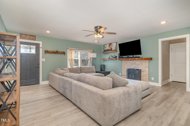 living area featuring ceiling fan, recessed lighting, a fireplace, baseboards, and light wood-style floors