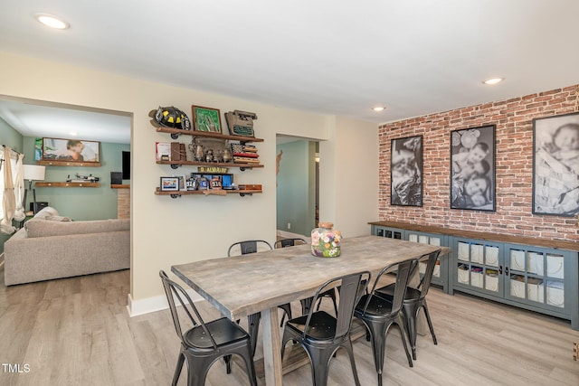 dining area with light wood finished floors, brick wall, baseboards, and recessed lighting