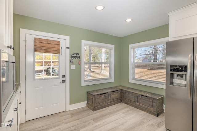 entryway featuring light wood-style floors, plenty of natural light, and baseboards