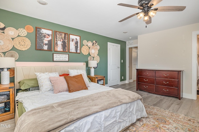 bedroom featuring ceiling fan, baseboards, and wood finished floors