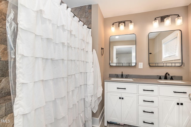 bathroom with a sink, a shower with shower curtain, and double vanity