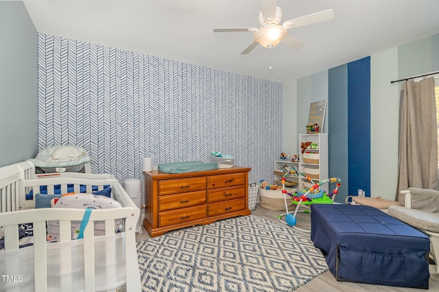 bedroom featuring an accent wall and ceiling fan