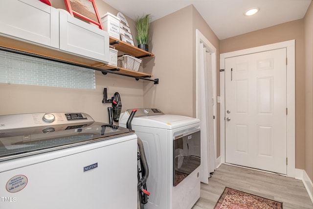 clothes washing area with recessed lighting, cabinet space, light wood-style floors, washer and dryer, and baseboards