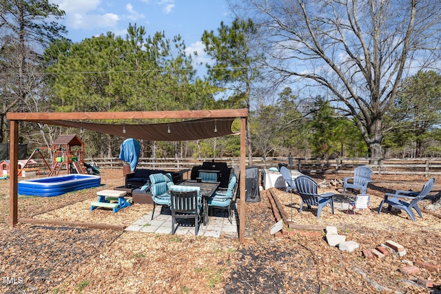 view of yard featuring a patio area, fence, and a playground