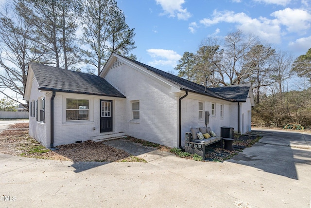 view of front facade with brick siding and roof with shingles