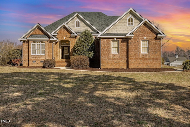 view of front of home featuring brick siding, crawl space, and a lawn