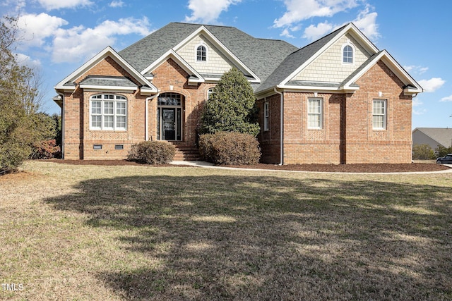 craftsman house featuring crawl space, brick siding, a front lawn, and roof with shingles