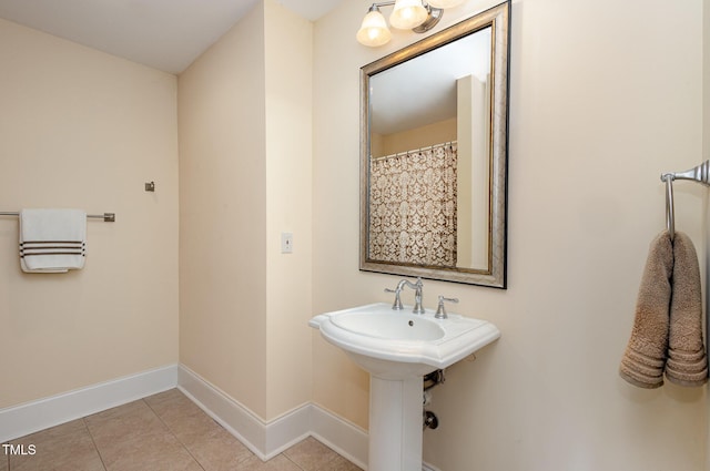 bathroom with baseboards and tile patterned floors