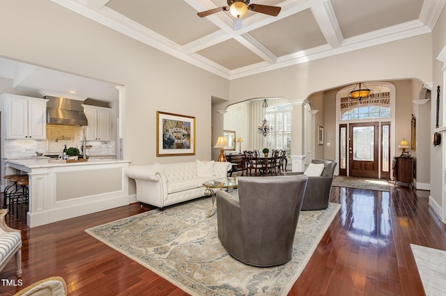 living room featuring arched walkways, a high ceiling, coffered ceiling, and dark wood-style floors