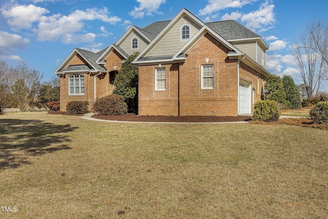 view of front of house featuring brick siding, a front yard, and a shingled roof