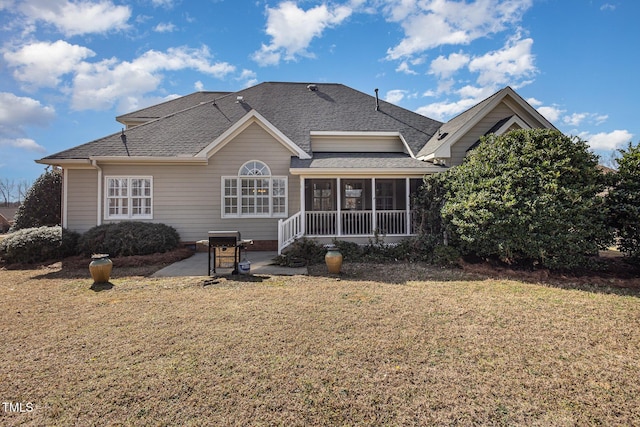 rear view of house with a yard, roof with shingles, a patio area, and a sunroom