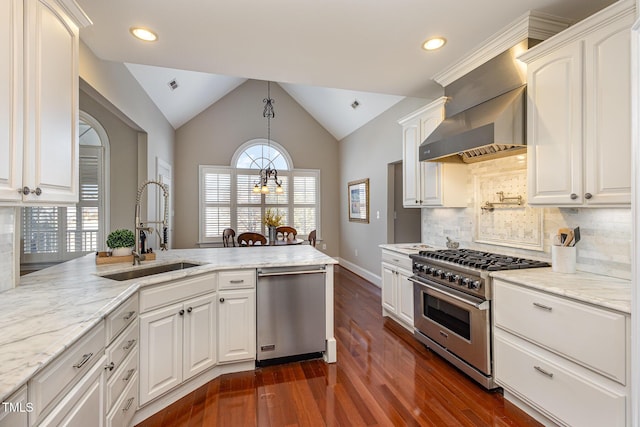 kitchen featuring stainless steel appliances, lofted ceiling, a sink, light stone countertops, and wall chimney exhaust hood