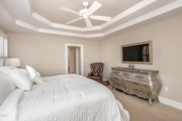 bedroom featuring a tray ceiling, carpet, ornamental molding, ceiling fan, and baseboards